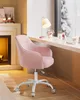A pink velvet desk chair is placed next to a window with a view of snow-covered trees. A desk with a lamp and makeup items is also visible. Produktbild-Vorschau