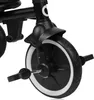 A close-up view of the front wheel and pedals of a black tricycle. Produktbild-Vorschau