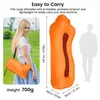 A woman carrying a folded orange inflatable sofa, with a diagram showing the inflated size and a silhouette of a person for scale. Produktbild-Vorschau