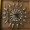 A silver kinetic wind spinner is placed inside a cardboard box. Anteprima dell’immagine prodotto