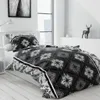 A bedroom scene with a bed made with black and white patterned bedding. Produktbild-Vorschau
