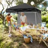 People enjoying a picnic under a pop-up canopy in a grassy outdoor setting. Náhled obrázku produktu