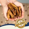 Hands holding dried chicken necks with a marketing badge overlay. Produktbild-Vorschau