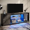 A modern TV stand with integrated RGB LED lighting, displaying various electronic devices and decorative items. Anteprima dell’immagine prodotto