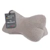 A taupe-colored bone-shaped pillow with a tag attached. Produktbild-Vorschau