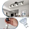A collage showing a black track light fixture installed on a ceiling, a close-up of a hand installing a light bulb, and a close-up of an LED light bulb. Produktbild-Vorschau