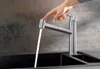 A hand is shown operating a modern kitchen faucet with a pull-out spray. Produktbild-Vorschau
