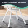Close-up of the white metal legs of a round table, with a rug and wooden floor in the background. Náhled obrázku produktu