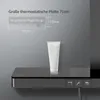 A close-up view of a modern shower system's control panel and shelf, with a white tube of product placed on the shelf. Produktbild-Vorschau