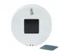 The back of a white, round LED light with a black square cutout is shown against a white background. A small square adhesive pad is placed in the foreground. Produktbild-Vorschau