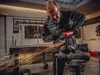 A man is using an angle grinder in a workshop. Podgląd zdjęcia produktu