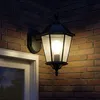 An outdoor wall lamp is mounted on a brick wall next to a white-framed window. Náhled obrázku produktu