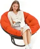 A woman is sitting in a round, orange cushion chair. Produktbild-Vorschau