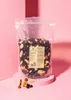 A bag of mixed nuts and dried fruit is displayed on a pink pedestal. Produktbild-Vorschau