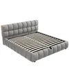 A grey upholstered bed frame with a slatted mattress base, shown from a three-quarter angle on a white background. Anteprima dell’immagine prodotto