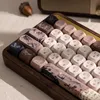 A close-up view of a mechanical keyboard with decorative keycaps, set against a light-colored surface with some shadows. Produktbild-Vorschau