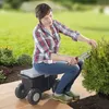 A woman is gardening while sitting on a wheeled garden cart. Produktbild-Vorschau