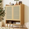 A wooden cabinet with rattan doors and open shelving, decorated with a vintage radio and books. Produktbild-Vorschau