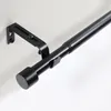Close-up of a black adjustable curtain rod mounted on a white wall. Produktbild-Vorschau