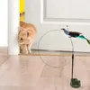 An orange cat is cautiously approaching a toy bird on a wand with a suction cup base. Voir les images du produit