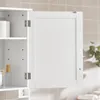 A white bathroom cabinet with its door slightly ajar, revealing shelves inside. The cabinet is mounted on a tiled wall. Voir les images du produit