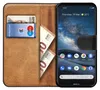 A book-style phone case with a Nokia smartphone inside, showing cards and money in the case. Náhled obrázku produktu