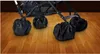 A close-up view of a stroller's wheels covered with black protective bags, resting on a wooden floor. Anteprima dell’immagine prodotto