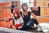 A woman and a child in boxing gear sitting in a boxing ring. Produktbild-Vorschau