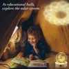 Two children are in a tent, reading a book with a lamp illuminating them. A decorative moon lamp is on the right. Náhled obrázku produktu