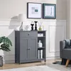 A gray cabinet with doors and shelves, decorated with a lamp, candles, and a plant. Produktbild-Vorschau