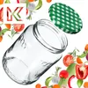 A clear glass jar with a green checkered lid is shown, surrounded by various fresh vegetables and herbs. Anteprima dell’immagine prodotto
