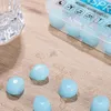 A close-up of light blue moldable silicone earplugs scattered on a wooden surface with water droplets. Produktbild-Vorschau