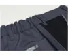 Close-up of the waistband and pocket of dark-colored trousers. Produktbild-Vorschau