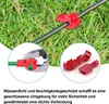 Close-up of red wire connectors attached to a black cable and a green wire, set against a background of green grass. Produktbild-Vorschau