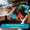 A person is holding a tablet on a wooden table with coffee cups and a notebook in the background. Produktbild-Vorschau