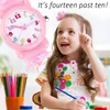 A young girl is looking up and pointing, with a pink watch on her wrist and a cup of colored pencils in the foreground. Produktbild-Vorschau