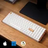 A white mechanical keyboard with wood accents is placed on a wooden desk, with icons for Apple, Windows, and Linux at the bottom. Anteprima dell’immagine prodotto