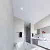 A modern, minimalist bathroom with a freestanding bathtub, a shower enclosure, and a vanity with a sink and mirror. Produktbild-Vorschau