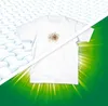 A white t-shirt with a brown stain is shown on the left, contrasted with a clean, bright white t-shirt on the right, against a green background with light rays. Náhľad obrázku produktu