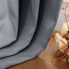 A close-up of a gray curtain with a bouquet of cream and gold flowers to the right. Produktbild-Vorschau