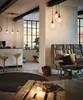 A modern living room and kitchen area with industrial-style pendant lights. Voir les images du produit