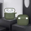 Two olive green silicone cases for Apple AirPods are displayed on dark platforms against a light gray and black background. Produktbild-Vorschau