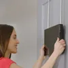 A woman is hanging a makeup mirror on a door. Podgląd zdjęcia produktu