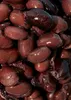 A close-up, overhead view of many black beans in liquid. Produktbild-Vorschau