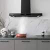 A modern kitchen counter with a black range hood, a stovetop with a copper pot, decorative vases, and stacked cups. Náhľad obrázku produktu