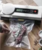 A vacuum sealer is shown with a steak and rosemary inside a vacuum bag on a wooden surface. Náhľad obrázku produktu