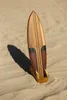 A wooden surfboard on a sandy beach. Produktbild-Vorschau