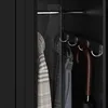Close-up view inside a wardrobe or closet, showing hanging clothes and an umbrella. Produktbild-Vorschau