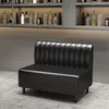 A black diner-style sofa is shown in a room with shelves of bottles in the background. Anteprima dell’immagine prodotto