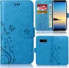 A collage of images showing a blue phone case with a floral and butterfly design, including a view of the inside with card slots and a phone inserted. Produktbild-Vorschau
